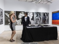 alex g cap infornt of his artworks